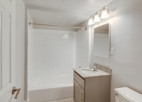 A white bathroom with a toilet, sink, and bathtub.