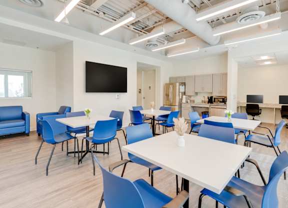 A conference room with blue chairs and a white table.
