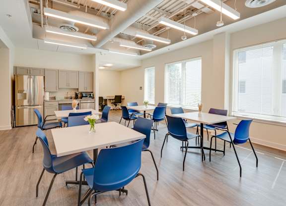 A conference room with blue chairs and a white table.