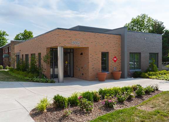 A red stop sign is on the front of a building.