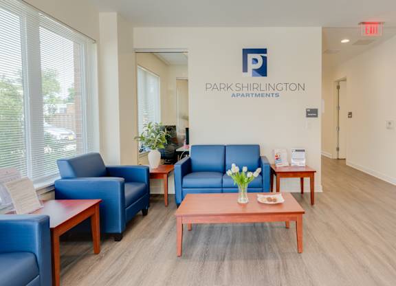 A waiting area with blue chairs and a brown table.