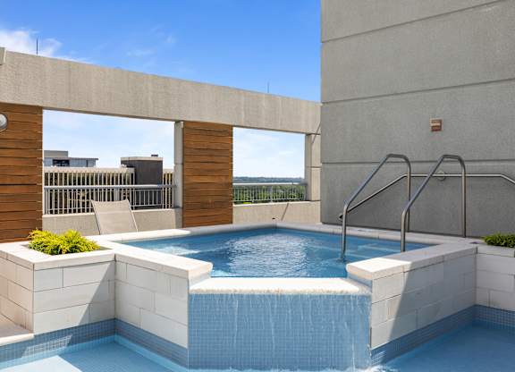 A small pool with a waterfall feature in the middle of it at Clayton on the Park Apartments, Missouri