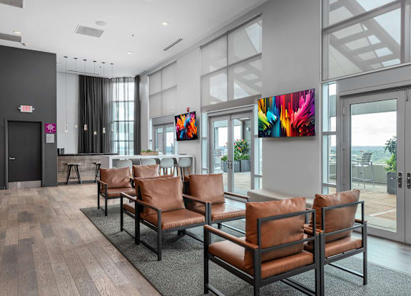 A waiting area with brown leather chairs and a large painting on the wall at Clayton on the Park Apartments, Missouri, 63105