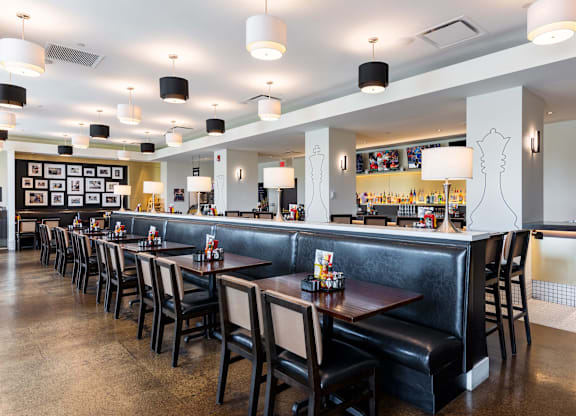 A restaurant with a long bar and black booths at Clayton on the Park Apartments, Clayton, MO, 63105
