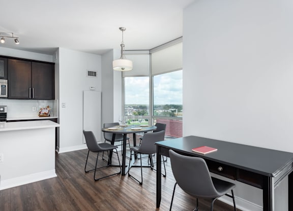 A modern kitchen with dark wood floors and white walls at Clayton on the Park Apartments, Clayton, MO