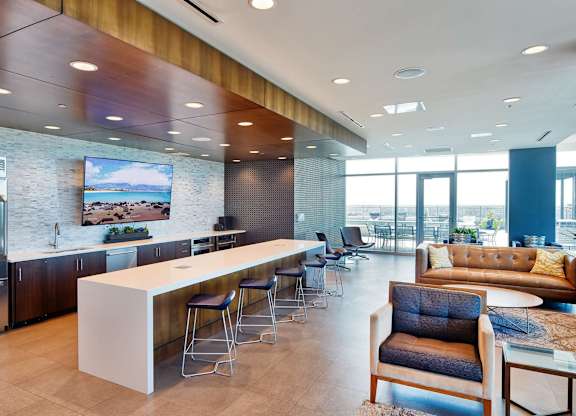 A modern kitchen with a bar and seating area.