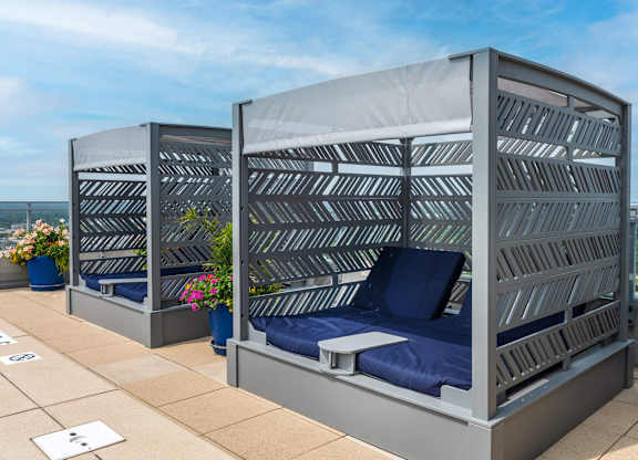 Two beds with blue pillows and grey striped headboards.