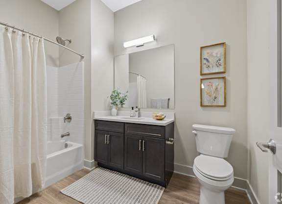 A bathroom with a white toilet, a white sink, and a white shower curtain.
