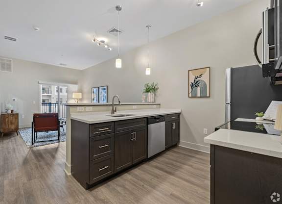 A kitchen with a white counter top and dark wood cabinets.
