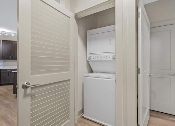A white washing machine is in a small laundry room.