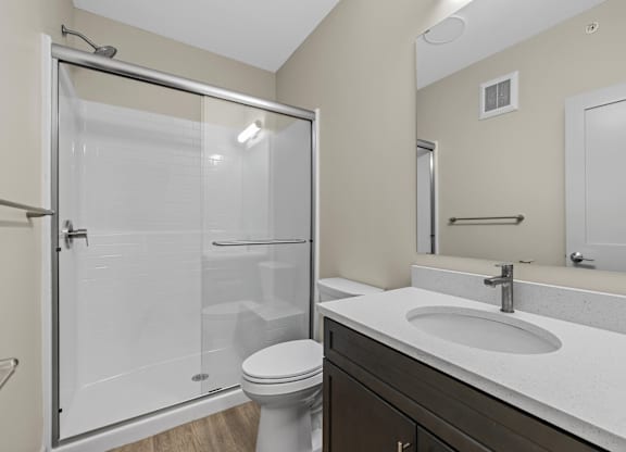 A bathroom with a toilet, sink, and shower.