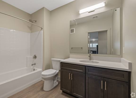 A white bathroom with a toilet, sink, and bathtub.