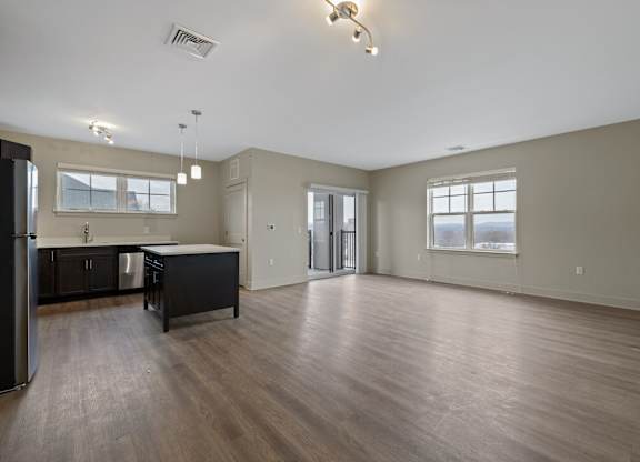A spacious kitchen with dark wood floors and a large island.
