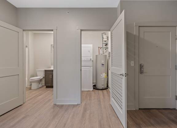 A white door is open to a bathroom with a toilet and sink.