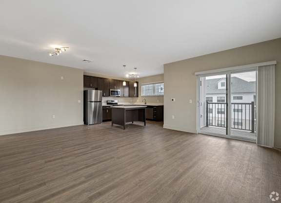 A spacious living room with a kitchenette and a dining table.