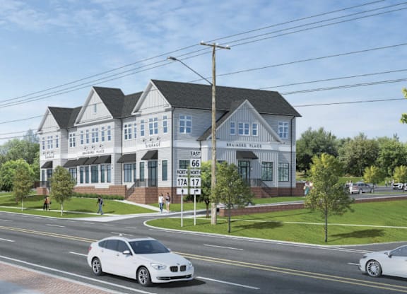 A white car is driving down a street past a house.