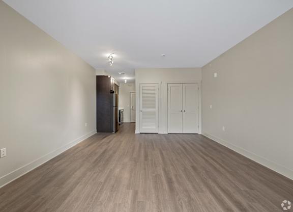 A room with wooden flooring and white walls.