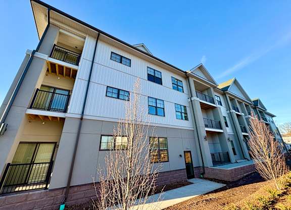 A modern apartment building with balconies and multiple windows.