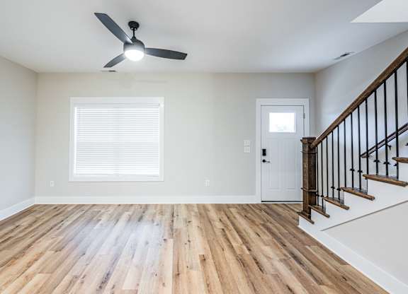 A room with a wooden floor and a ceiling fan.