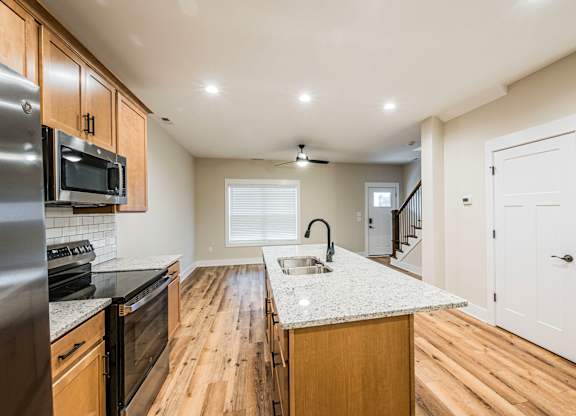 A kitchen with wooden floors and a white counter top.