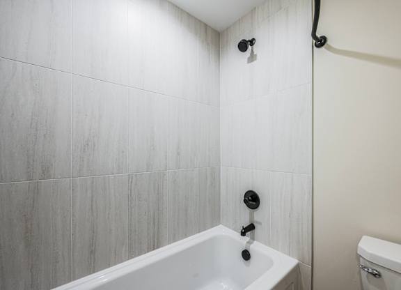 A white bathroom with a tub and toilet.