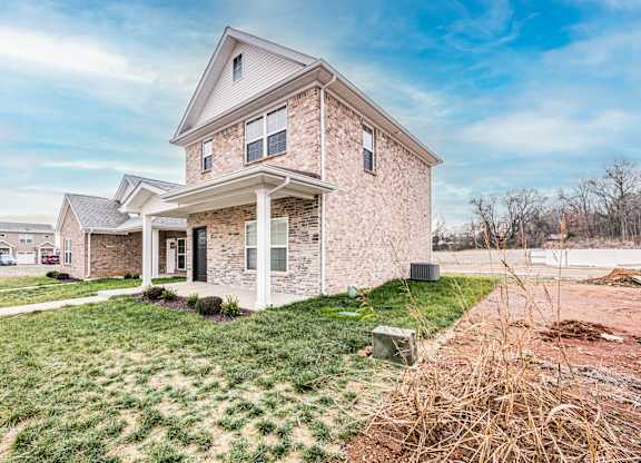 A house with a front yard and a driveway.