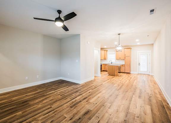 A room with wooden floors and a ceiling fan.