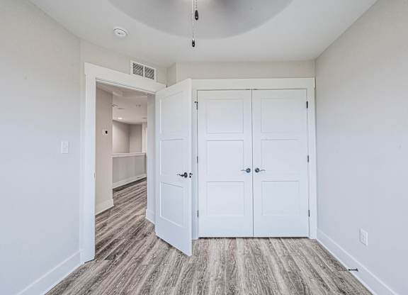 A room with a white door and a grey floor.