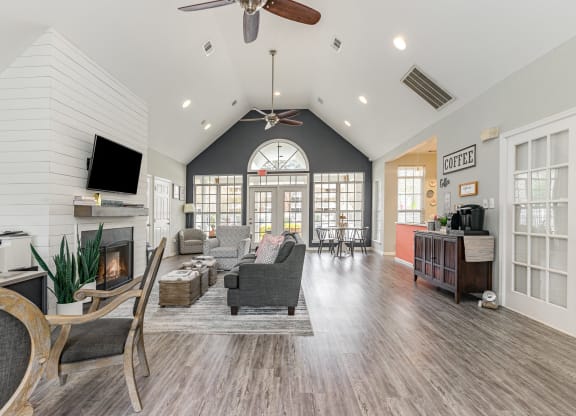 a living room with a fireplace and a ceiling fan at Litchfield Oaks Apartments, South Carolina