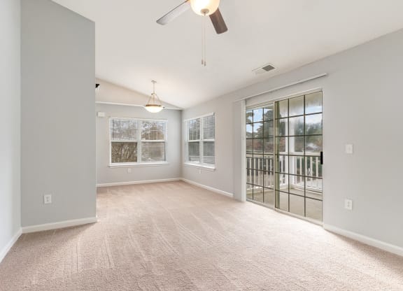 an empty living room with a door to a balcony