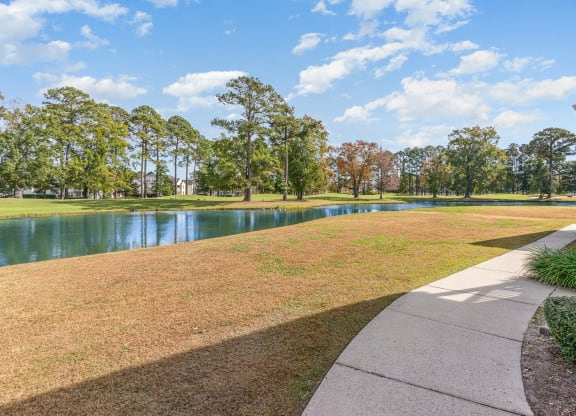 the view of a lake from a house with a sidewalk