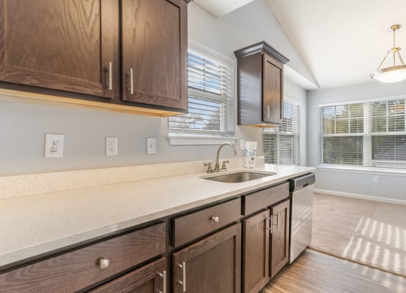 an empty kitchen with wooden cabinets and a sink