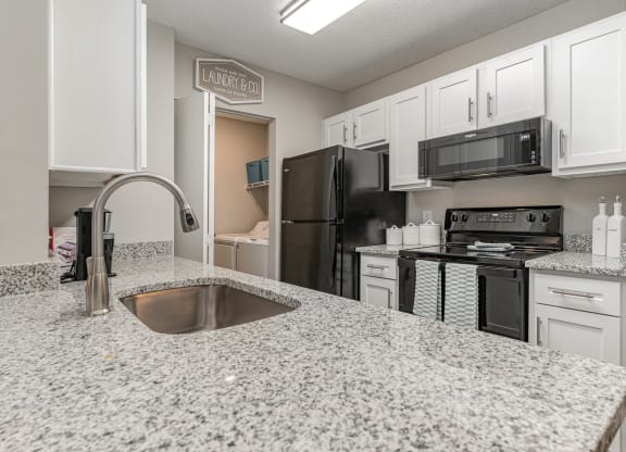an open kitchen with granite counter tops and black appliances at Litchfield Oaks Apartments, Pawleys Island