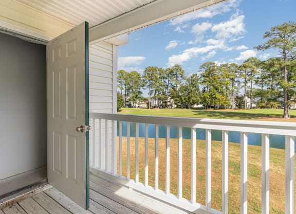 the view from the porch of a house with a door open to a porch swing