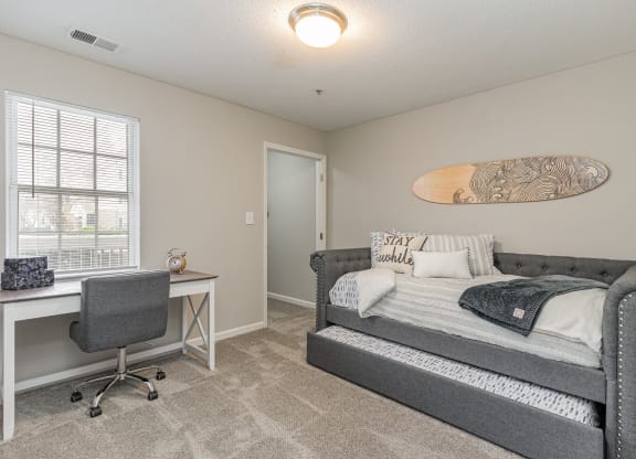 a bedroom with a bed and a desk and a window at Litchfield Oaks Apartments, South Carolina