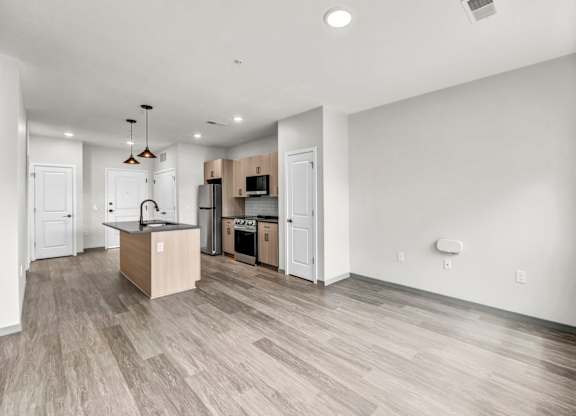 A kitchen with a wooden floor and white walls.