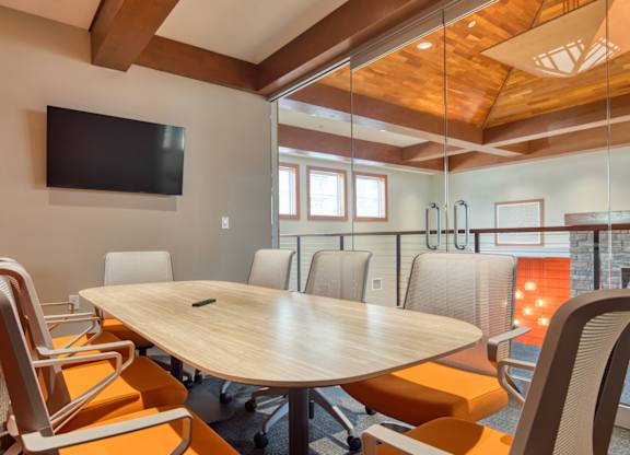 A conference room with a large table and chairs.