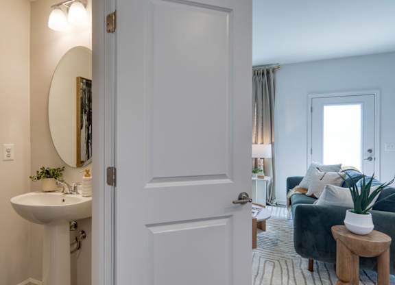 A bathroom with a white sink and a mirror on the wall at The Mark Townhomes Apartments, Virginia, 22801