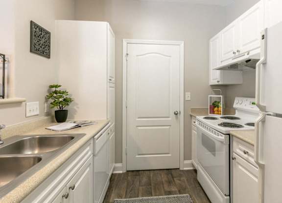 A small white kitchen with a sink and a stove.
