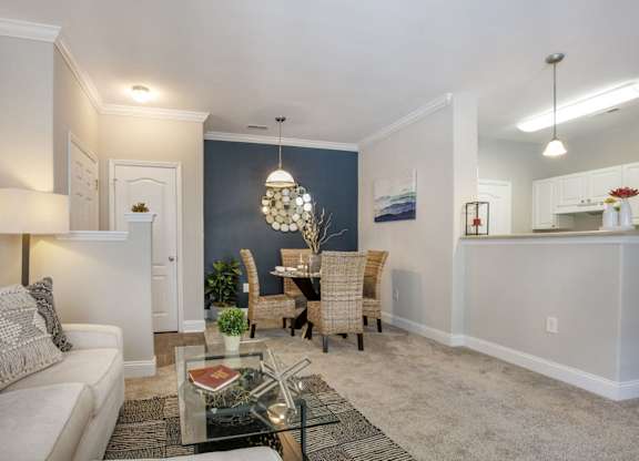 a living room and dining room with a table and chairs