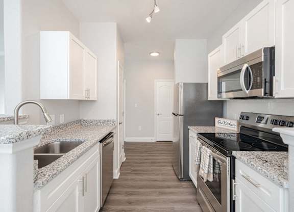 a kitchen with granite counter tops and stainless steel appliances
