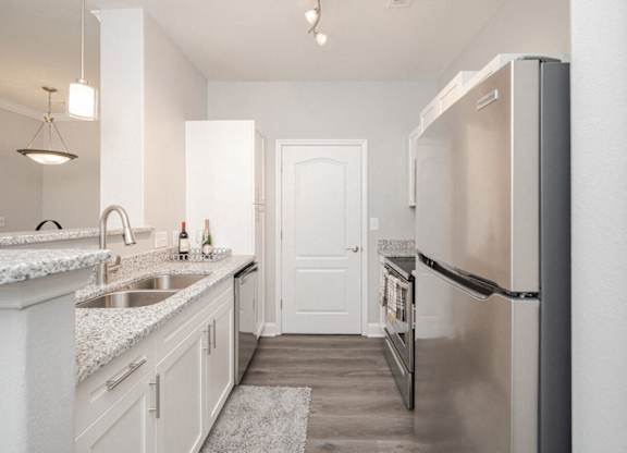 a kitchen with stainless steel appliances and white cabinets