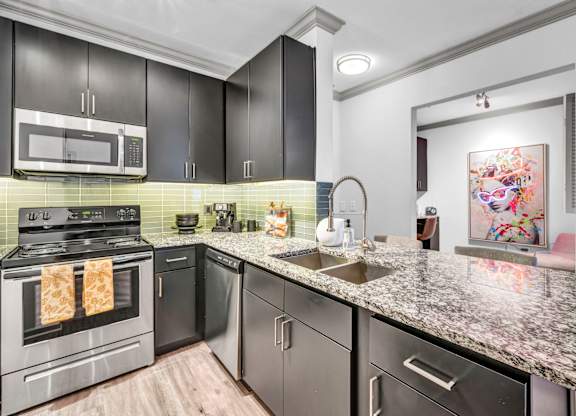 A modern kitchen with granite countertops and stainless steel appliances.