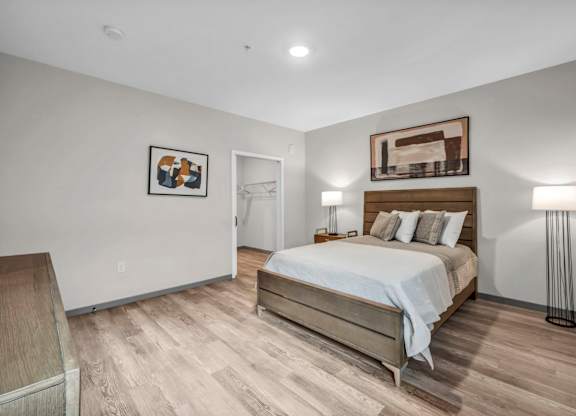 A bedroom with a bed, nightstand, and lamp.