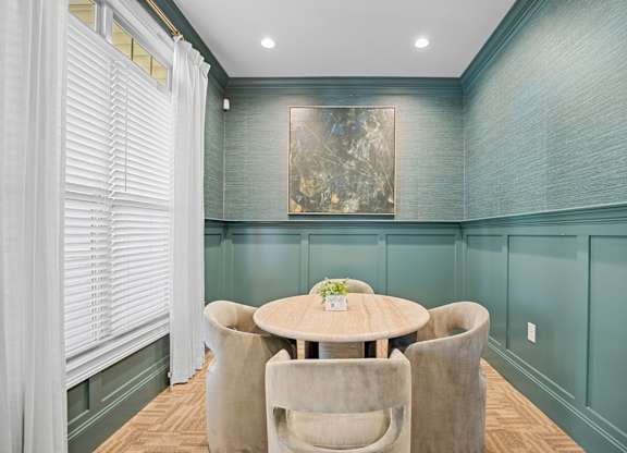 A dining room with a round table and chairs.