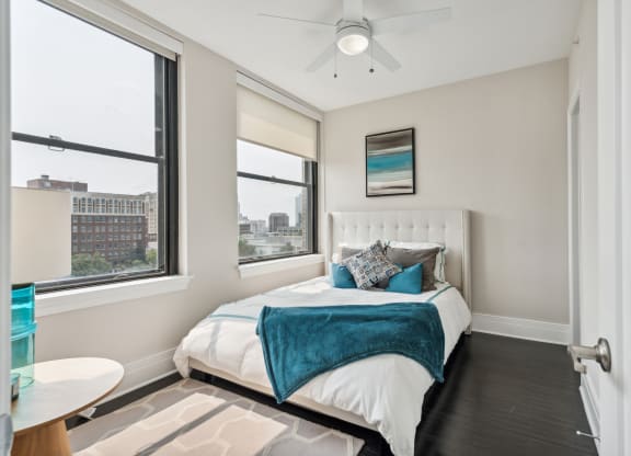 a bedroom with a bed and two windows