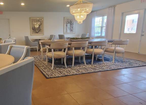 A dining room with a table and chairs.