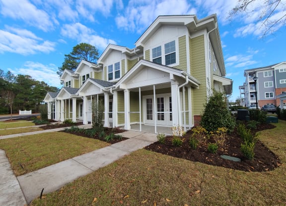 a large yellow house with a sidewalk in front of it at Barclay Place Apartments, Wilmington, NC, 28412