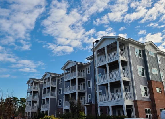 a row of apartment buildings with a blue sky in the background  at Barclay Place Apartments, Wilmington, NC, 28412