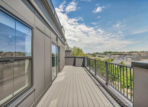 A balcony with a wooden floor and a metal railing.